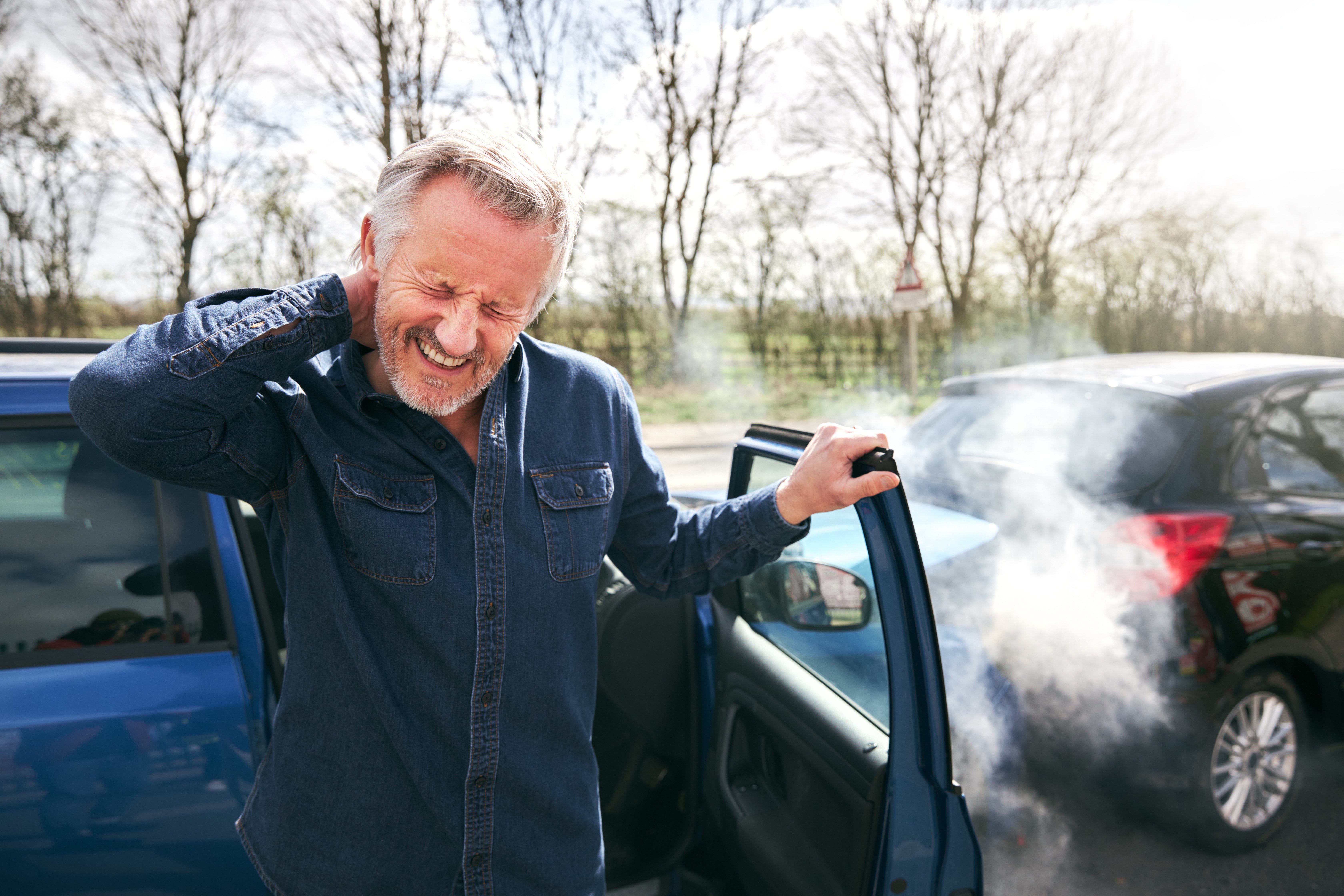 An image of a man holding his neck after being injured in a car accident.