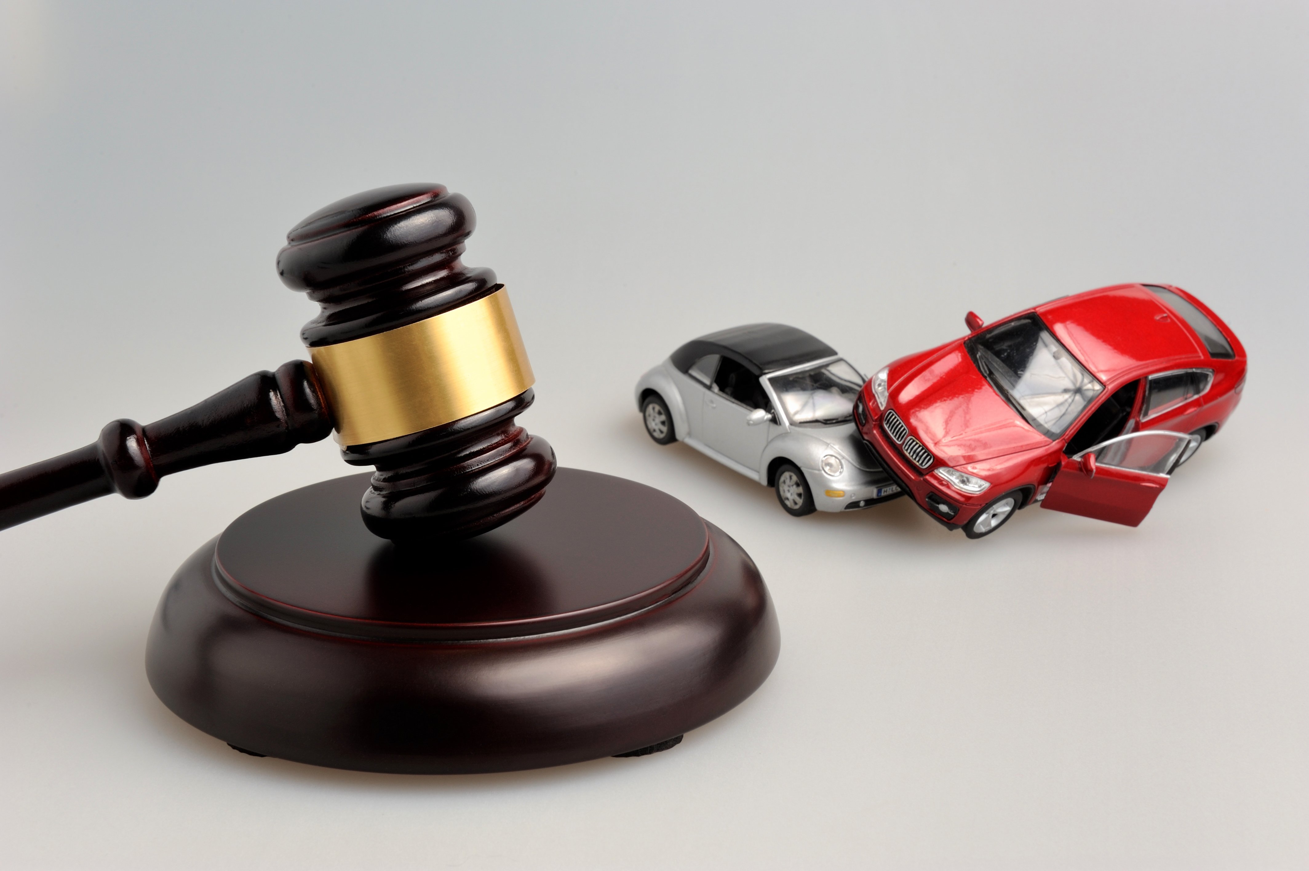 A gavel sits next to toy cars in an accident representing a car accident in which the victim asks how long after an accident can you file a claim